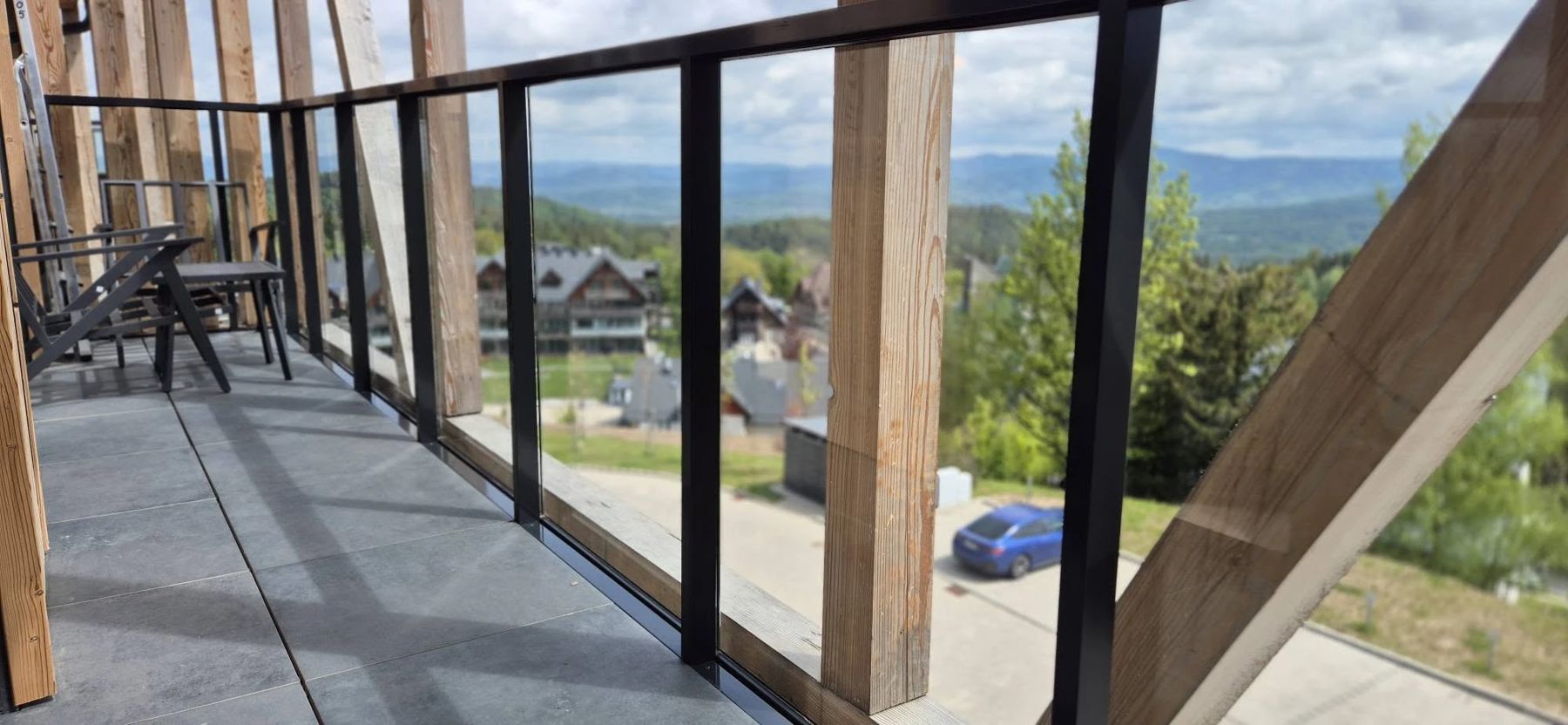 Balkon ze szklaną balustradą i widokiem na góry